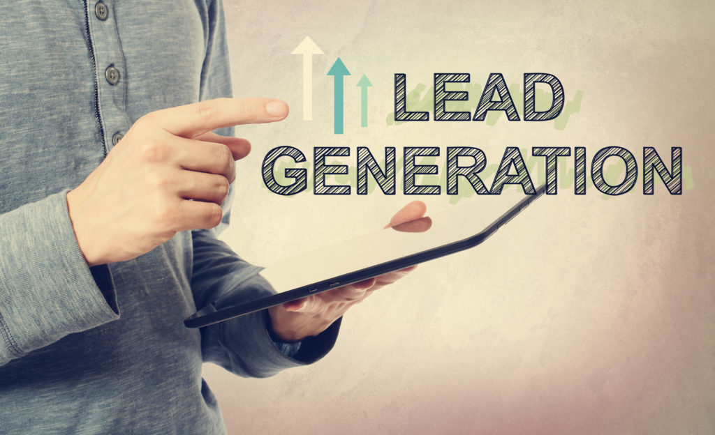 Young man pointing at Lead Generation text over a tablet computer